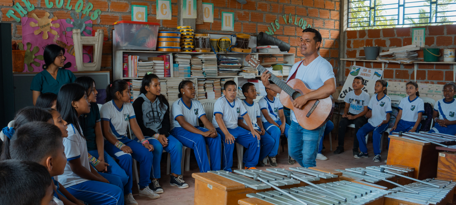 Teacher with sutdents playing music for the project Acordes in Colombia.